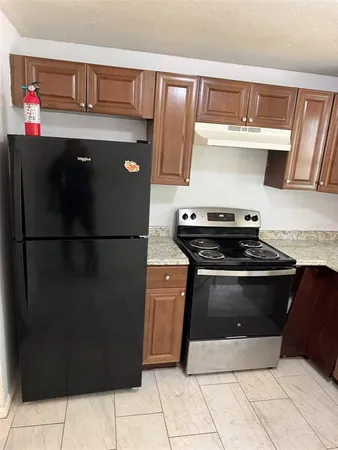 a kitchen with stainless steel appliances granite countertop a refrigerator and a stove