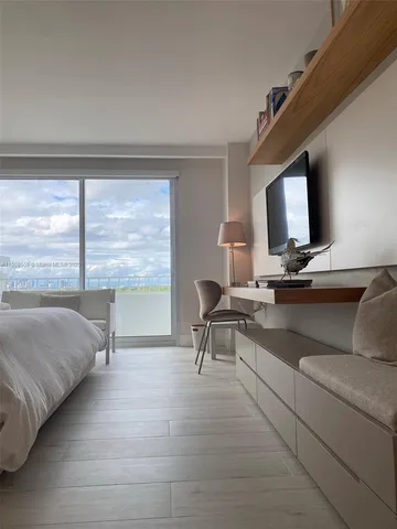 a bedroom with a large bed and a large window