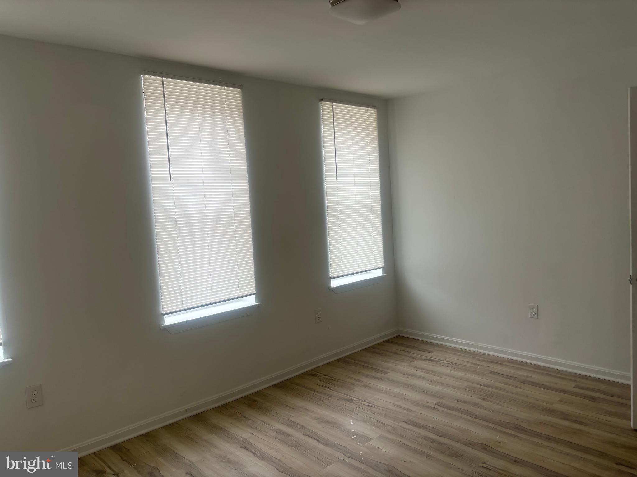 1623 West Lexington Street Baltimore, MD 21223 - Photo 18 of 26 an empty room with wooden floor and windows