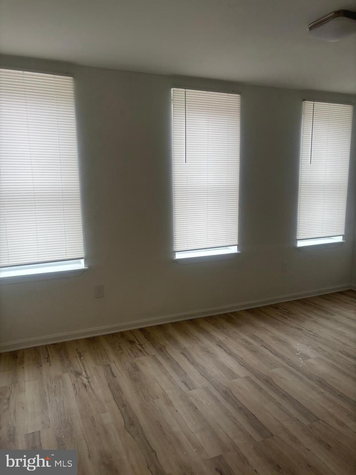 1623 West Lexington Street Baltimore, MD 21223 - Photo 19 of 26 an empty room with wooden floor and windows