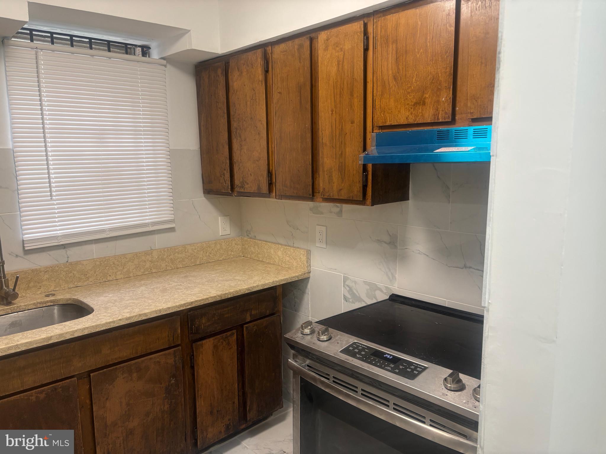 1623 West Lexington Street Baltimore, MD 21223 - Photo 20 of 26 a kitchen with a sink a stove and a microwave