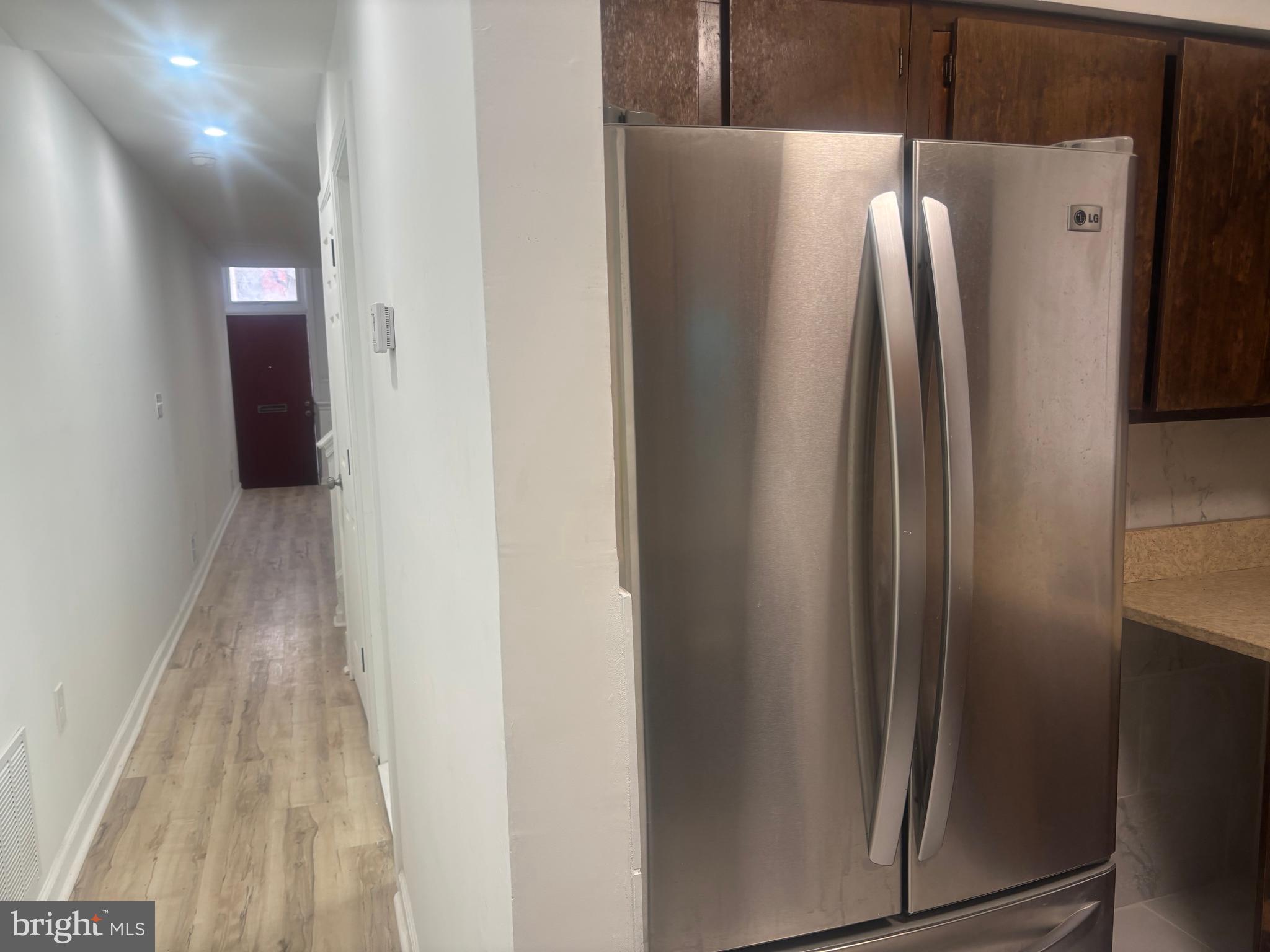 1623 West Lexington Street Baltimore, MD 21223 - Photo 21 of 26 a close view of a refrigerator in kitchen and an empty room