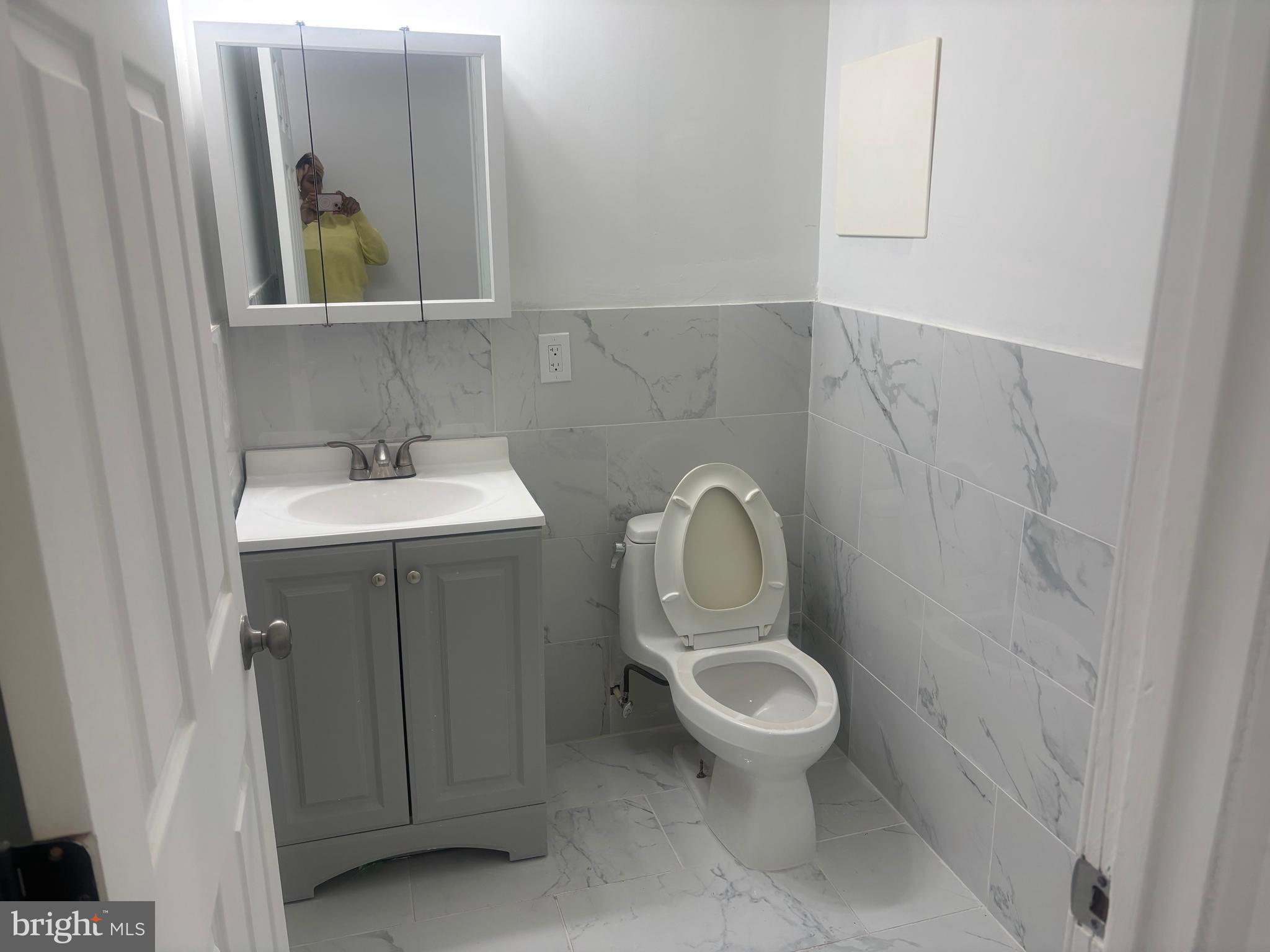 1623 West Lexington Street Baltimore, MD 21223 - Photo 23 of 26 a bathroom with a toilet sink and mirror