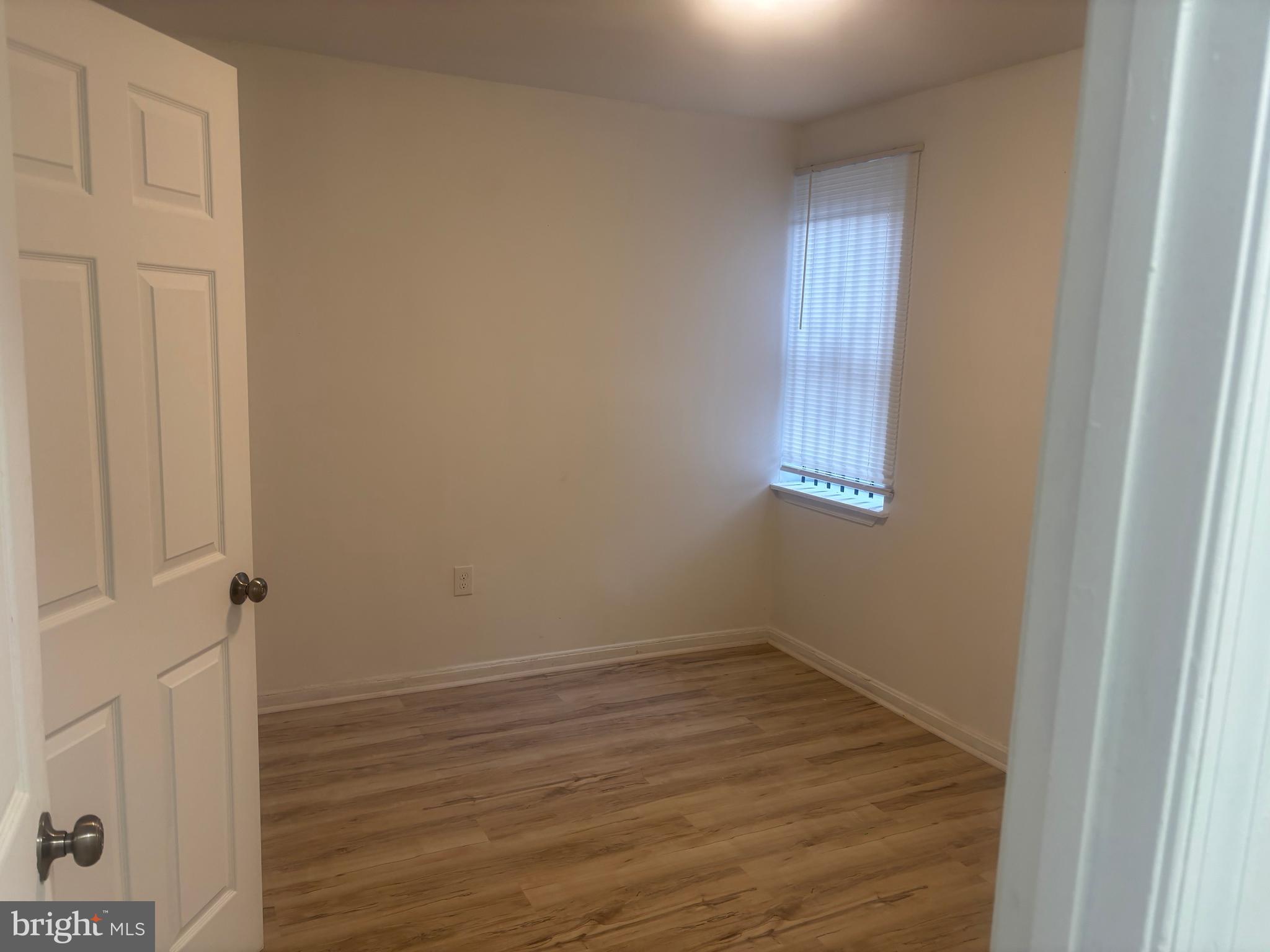 1623 West Lexington Street Baltimore, MD 21223 - Photo 24 of 26 an empty room with wooden floor and windows