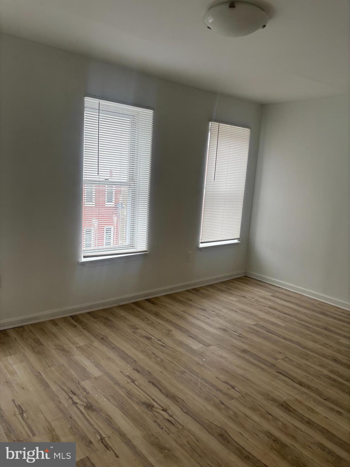 1623 West Lexington Street Baltimore, MD 21223 - Photo 8 of 26 an empty room with wooden floor and windows
