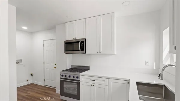 a kitchen with white cabinets and stainless steel appliances