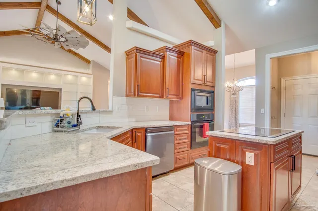a kitchen with stainless steel appliances granite countertop a sink and a refrigerator