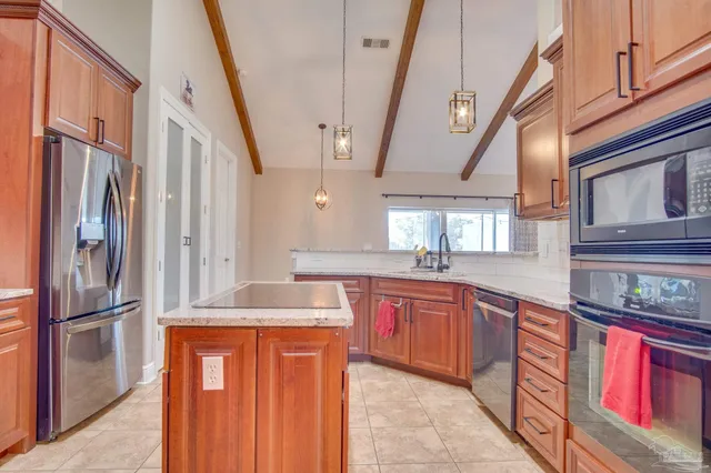 a kitchen with stainless steel appliances granite countertop a refrigerator and a sink