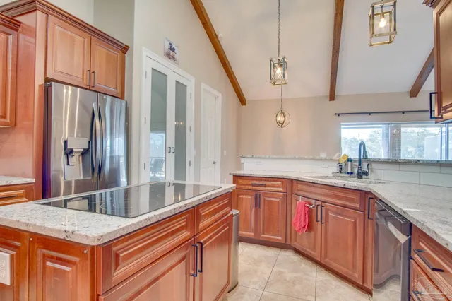 a kitchen with stainless steel appliances granite countertop a sink and dishwasher with wooden cabinets