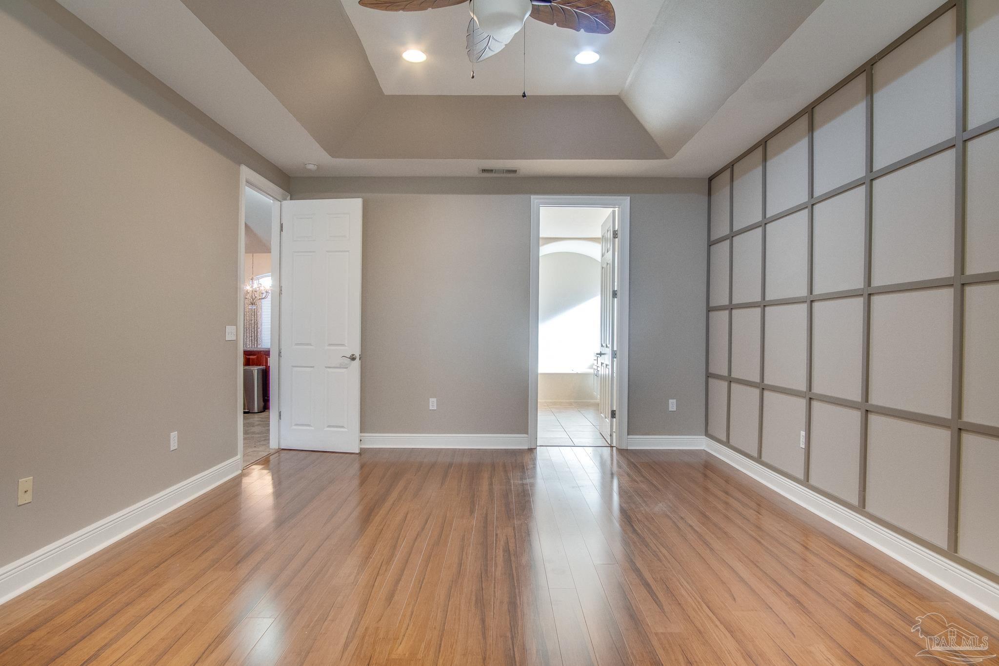 2655 Masters Boulevard Navarre, FL 32566 - Photo 18 of 43 wooden floor in an empty room with a window