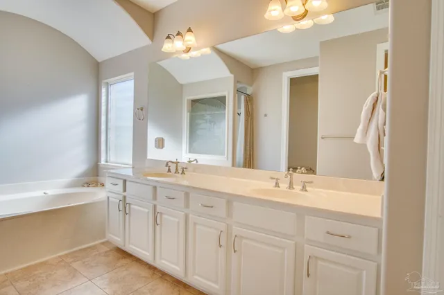 a bathroom with a double vanity sink mirror and a bathtub
