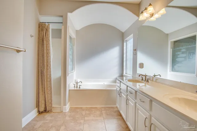 a spacious bathroom with a tub sink and a mirror