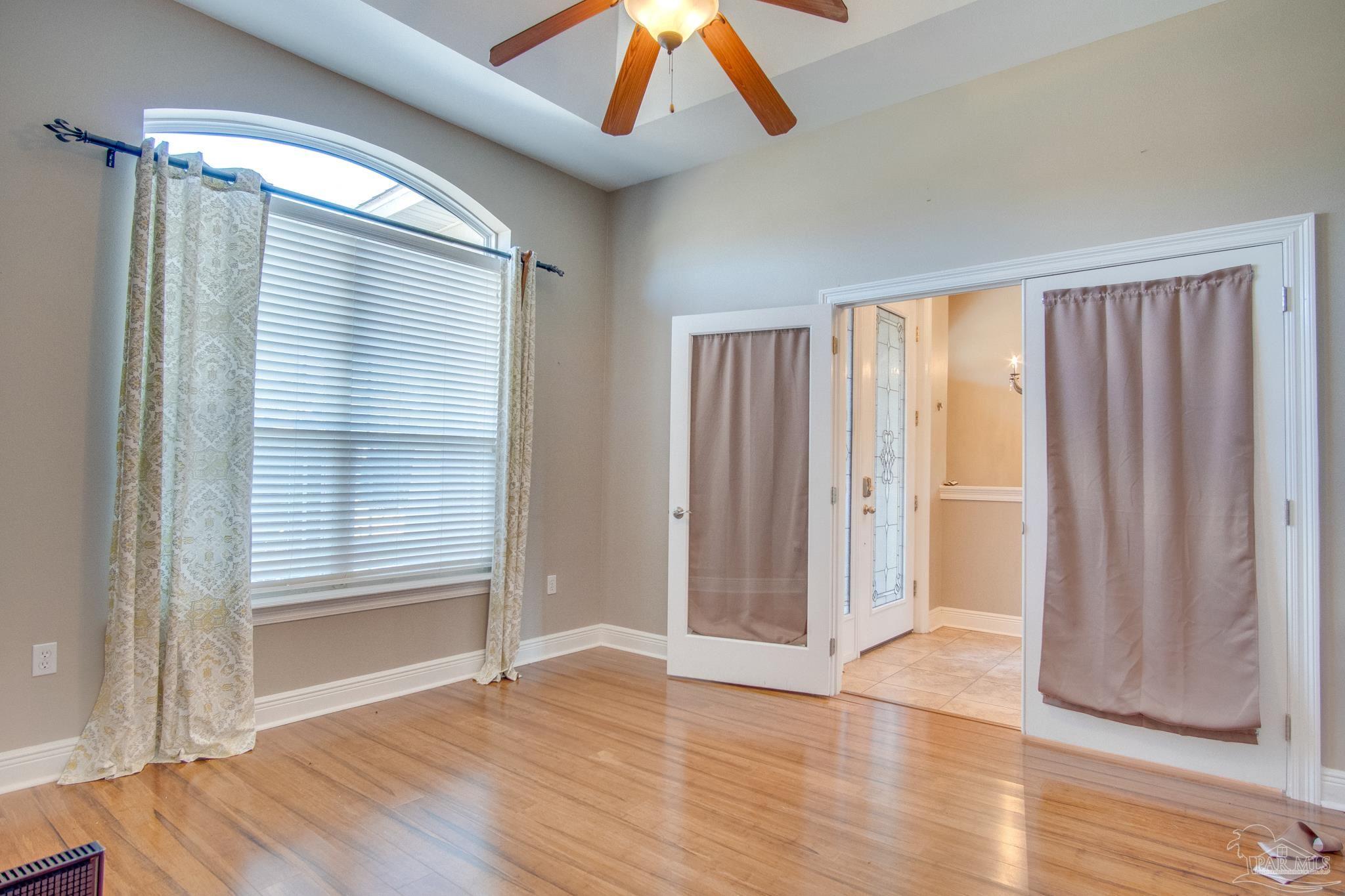 2655 Masters Boulevard Navarre, FL 32566 - Photo 24 of 43 an empty room with wooden floor and windows