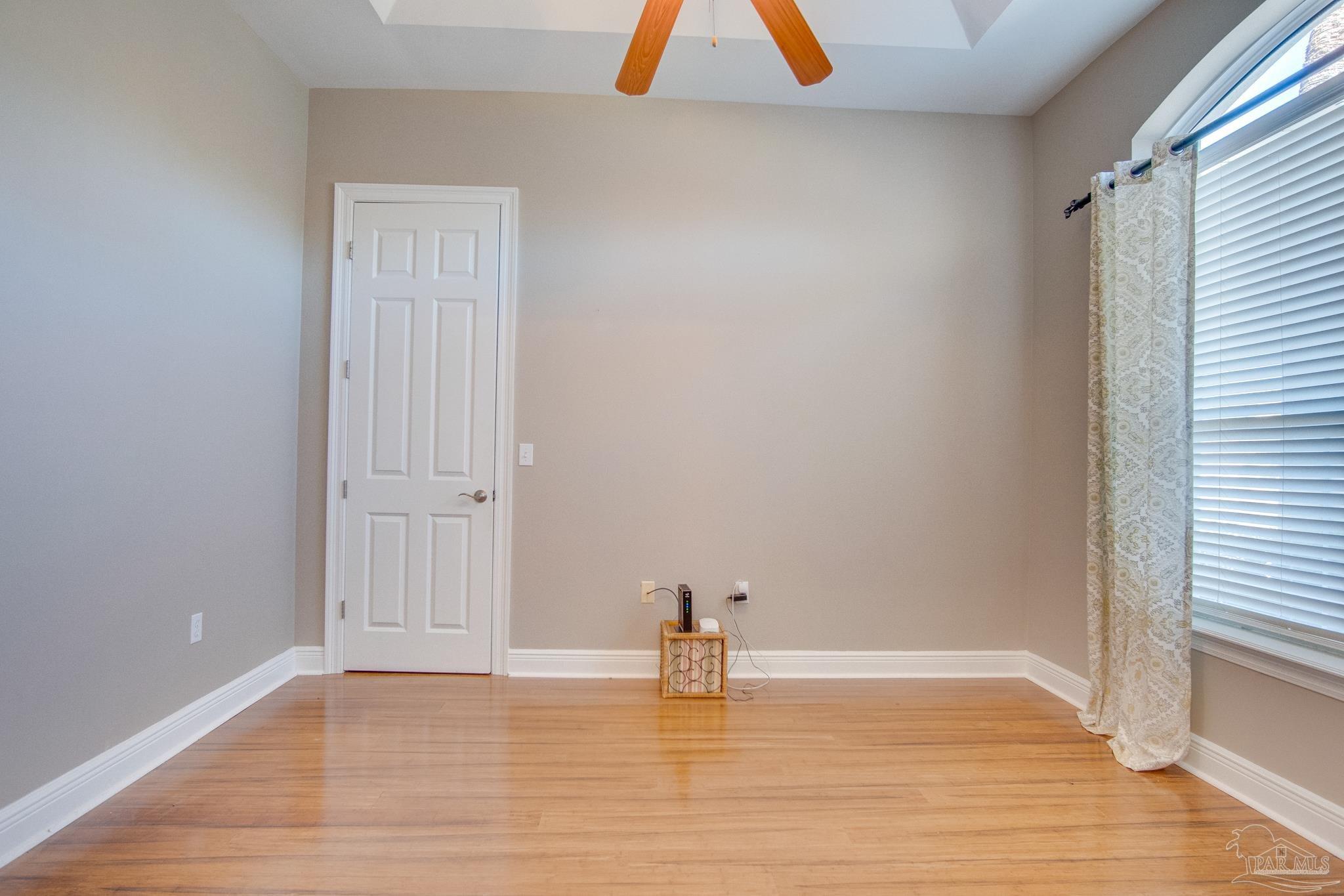 2655 Masters Boulevard Navarre, FL 32566 - Photo 28 of 43 a view of an empty room with wooden floor and a window
