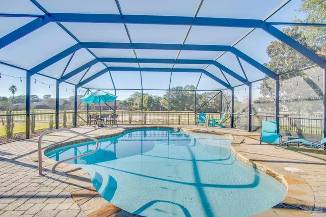 a room with view of a swimming pool and outdoor seating