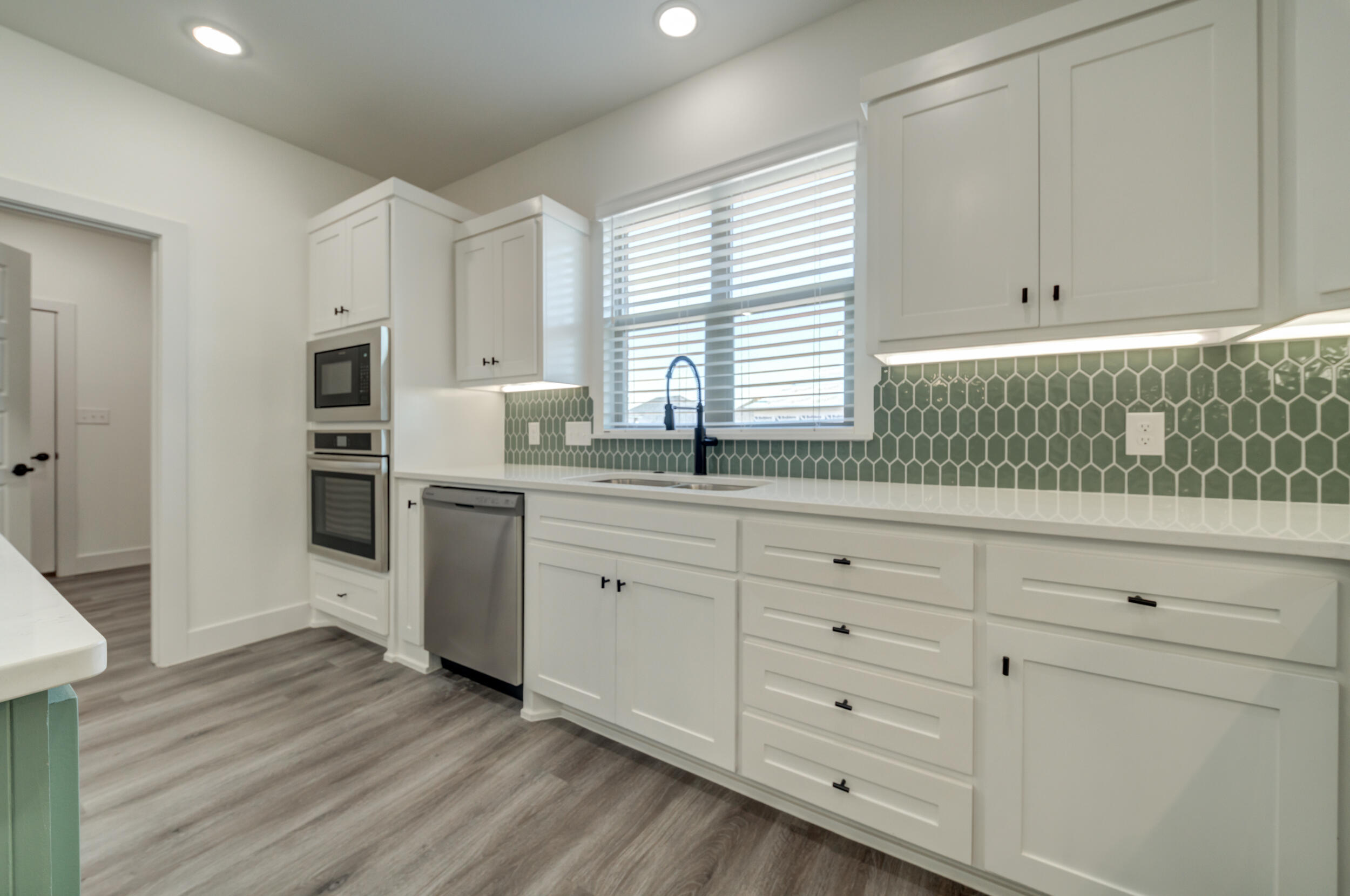 7522 56th Street Lubbock, TX 79407 - Photo 20 of 47 a kitchen with granite countertop white cabinets and white appliances