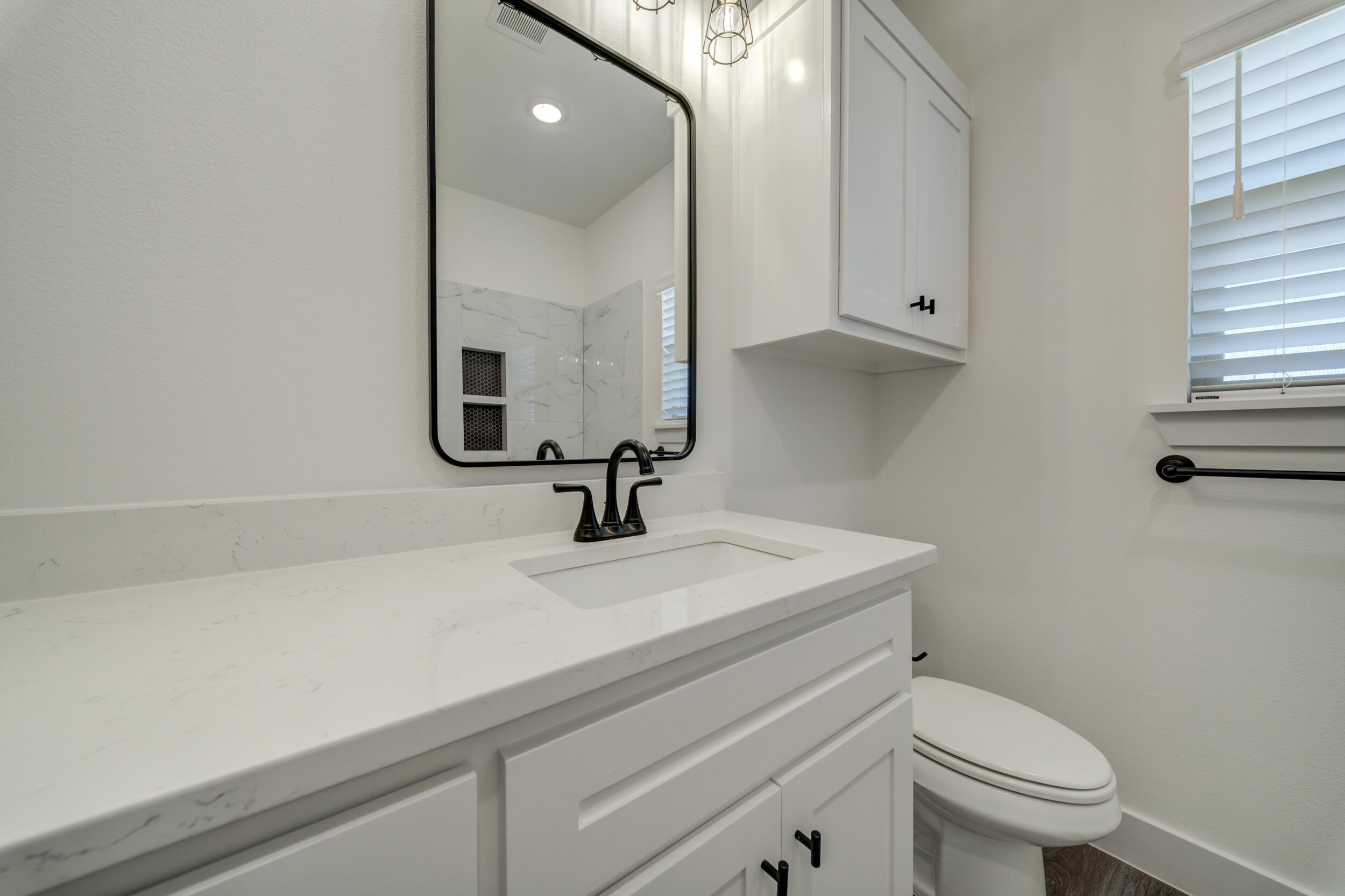 7522 56th Street Lubbock, TX 79407 - Photo 29 of 47 a bathroom with a sink a toilet and mirror