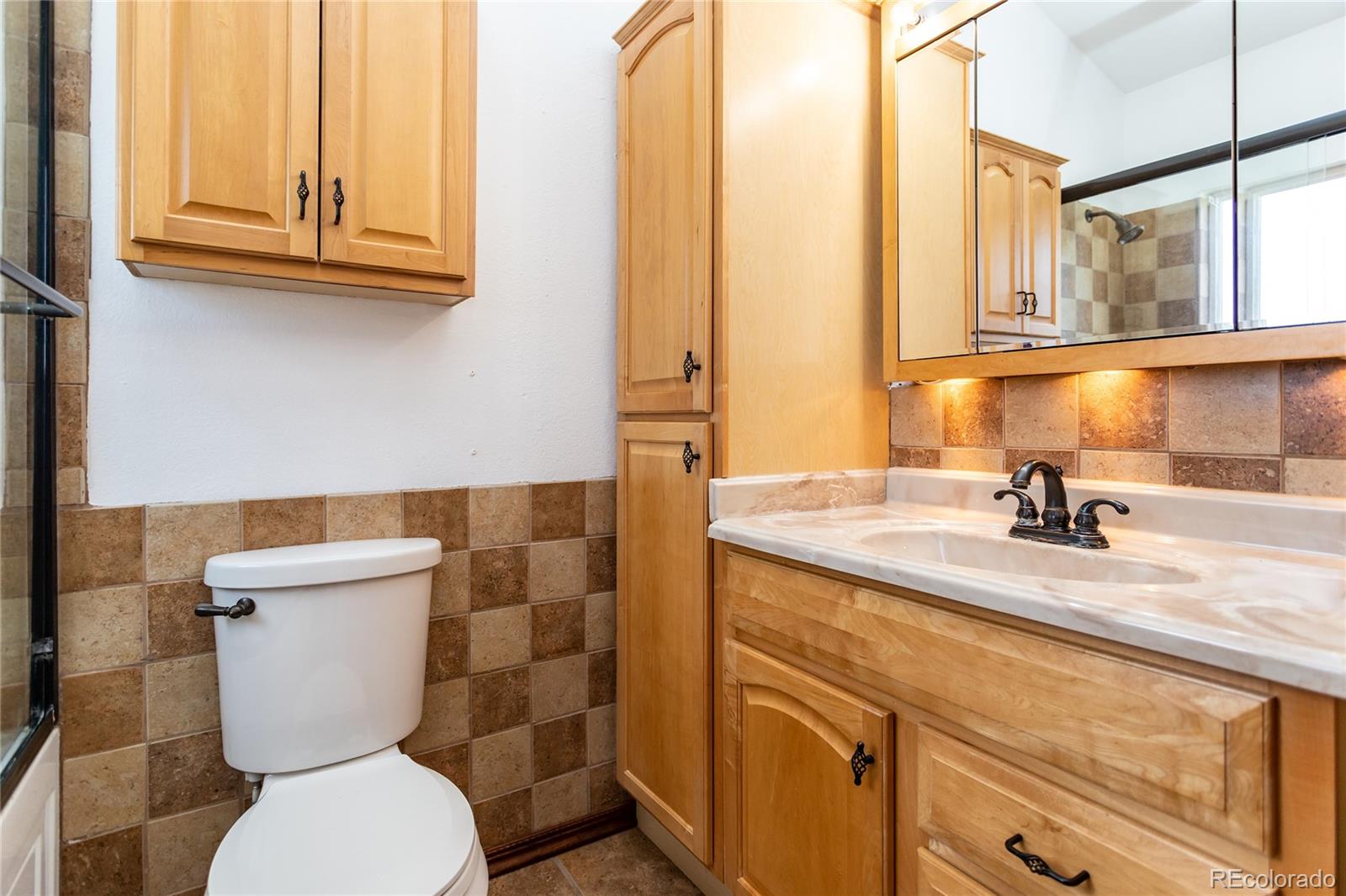 650 Howe Circle Castle Rock, CO 80104 - Photo 18 of 45 a bathroom with a granite countertop toilet sink and mirror