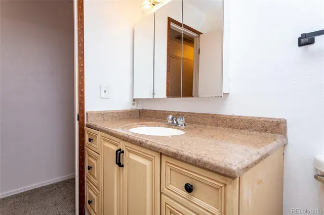 a bathroom with a granite countertop sink and a mirror