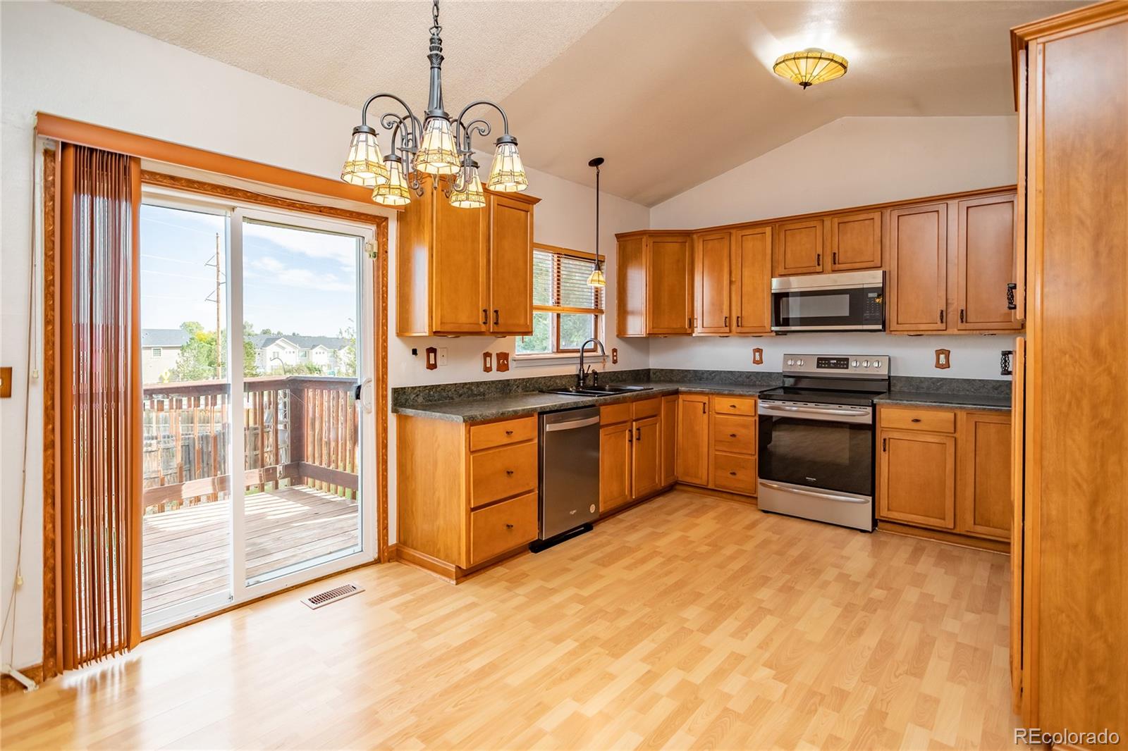 650 Howe Circle Castle Rock, CO 80104 - Photo 9 of 45 a kitchen with stainless steel appliances granite countertop a stove top oven a sink dishwasher a dining table and chairs