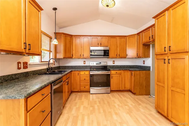 a kitchen with stainless steel appliances granite countertop a sink a stove and a refrigerator