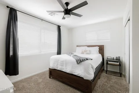 a bedroom with a bed and a ceiling fan