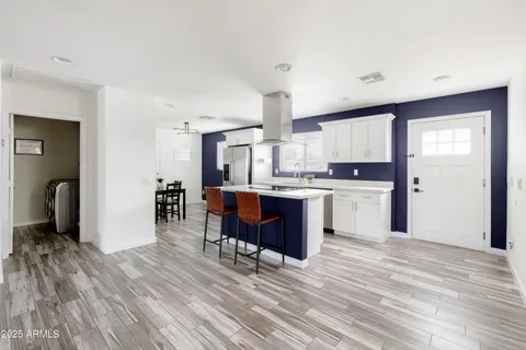 a kitchen with kitchen island granite countertop wooden floors and wooden cabinets