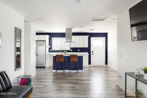 a living room with stainless steel appliances kitchen island granite countertop furniture and a fireplace