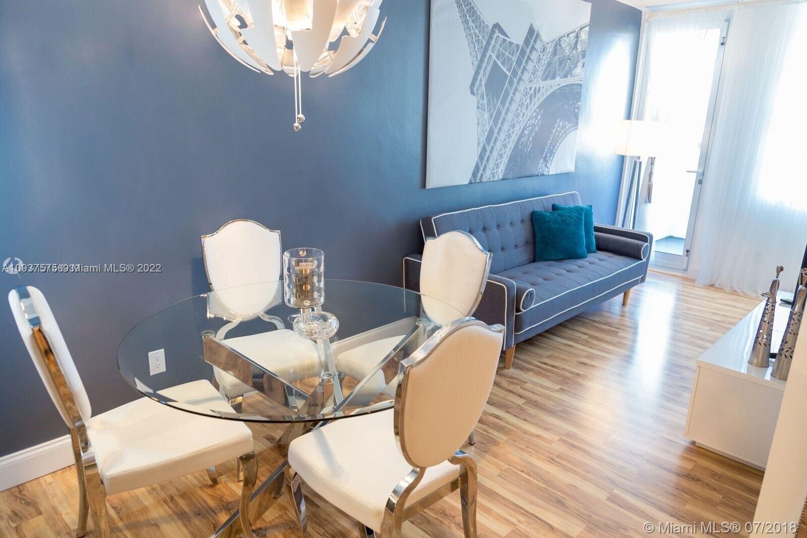 100 Lincoln Road, Unit 309 Miami Beach, FL 33139 - Photo 3 of 17 a view of a dining room with furniture a chandelier and wooden floor