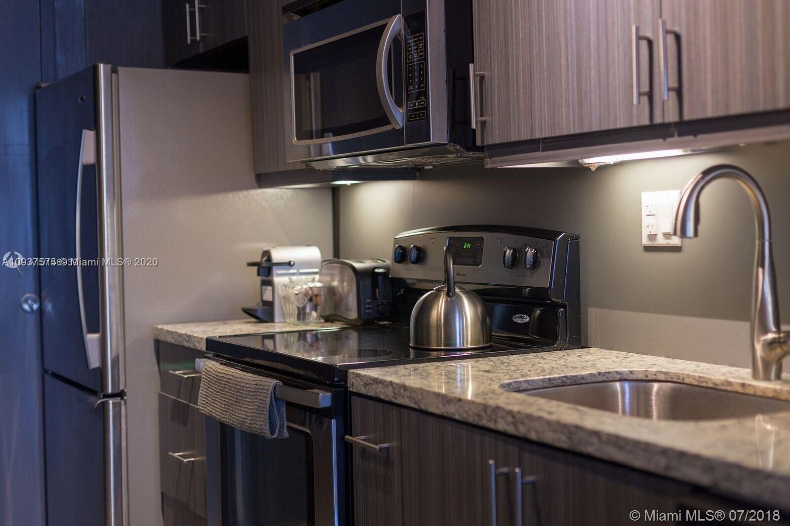 100 Lincoln Road, Unit 309 Miami Beach, FL 33139 - Photo 4 of 17 a kitchen with a sink and a microwave