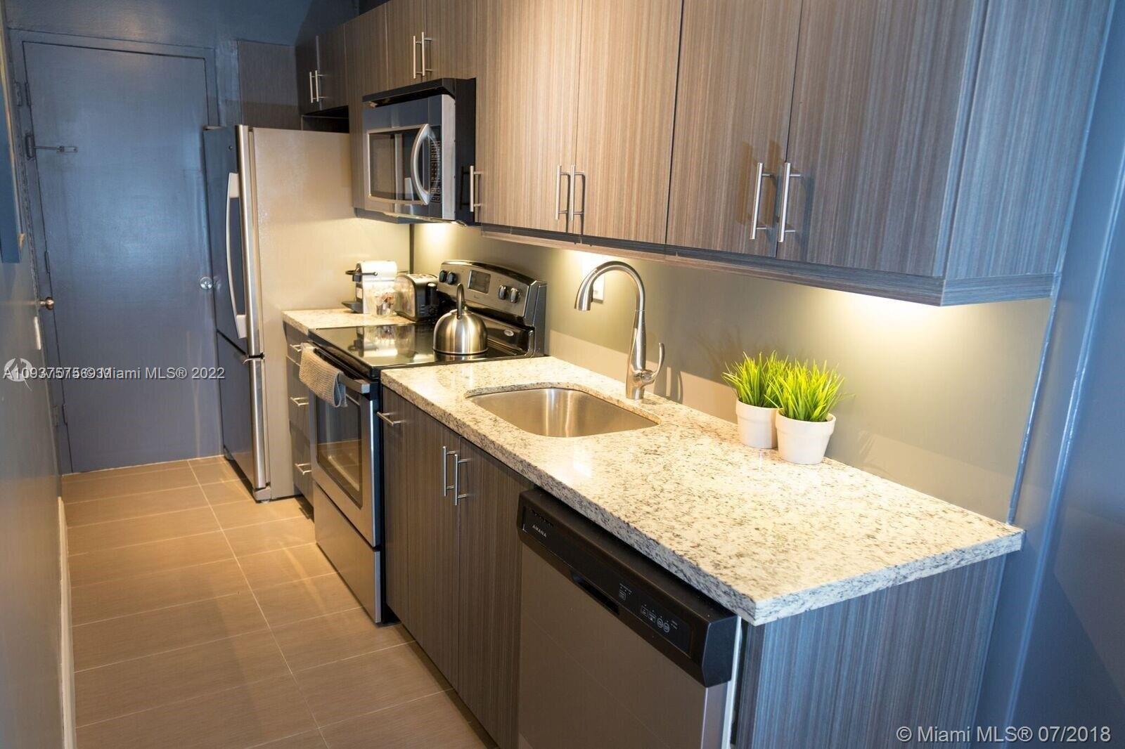 100 Lincoln Road, Unit 309 Miami Beach, FL 33139 - Photo 5 of 17 a kitchen with stainless steel appliances granite countertop a sink stove and refrigerator