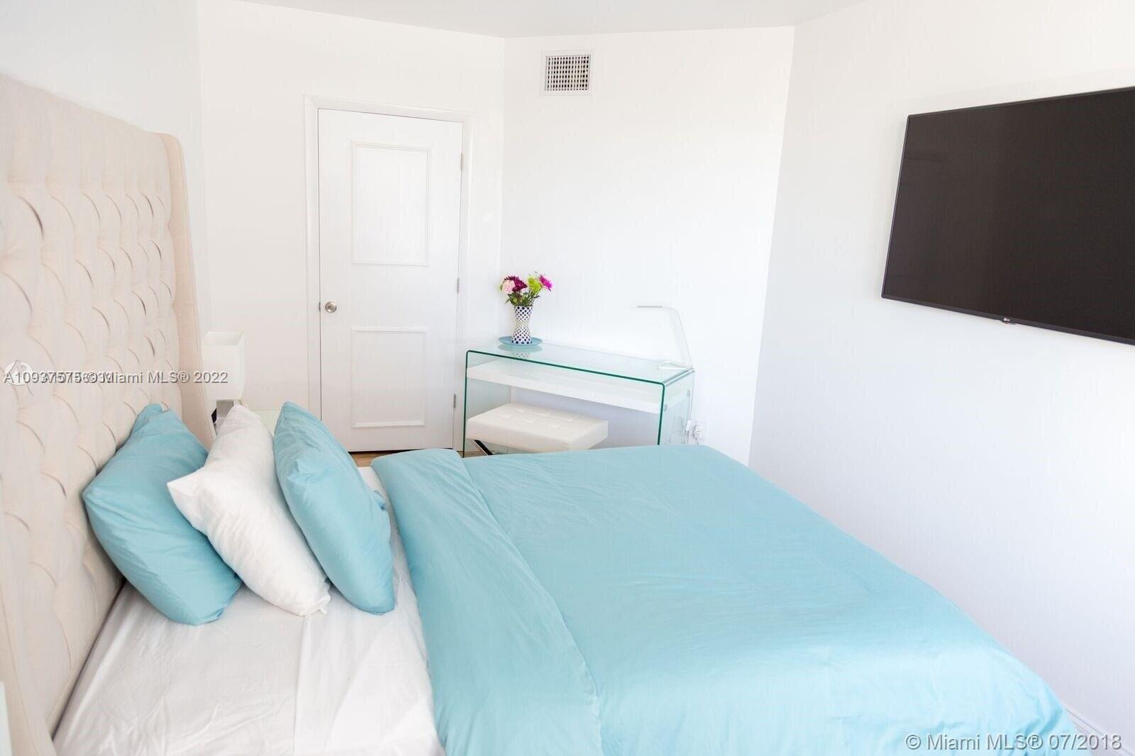 100 Lincoln Road, Unit 309 Miami Beach, FL 33139 - Photo 6 of 17 a bedroom with a bed and a potted plant