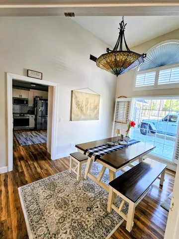 a dining room with wooden floor and a rug