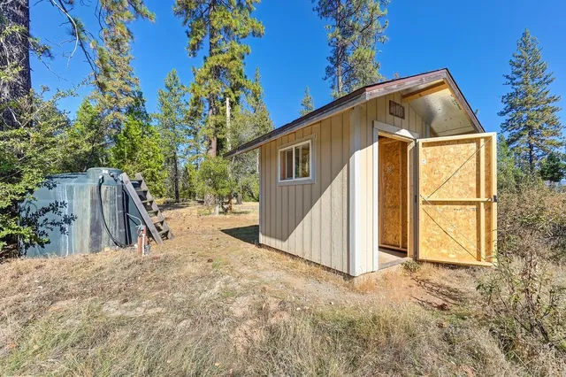 a view of a house with backyard and tree