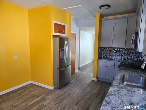 a view of kitchen with stainless steel appliances granite countertop a refrigerator and a stove