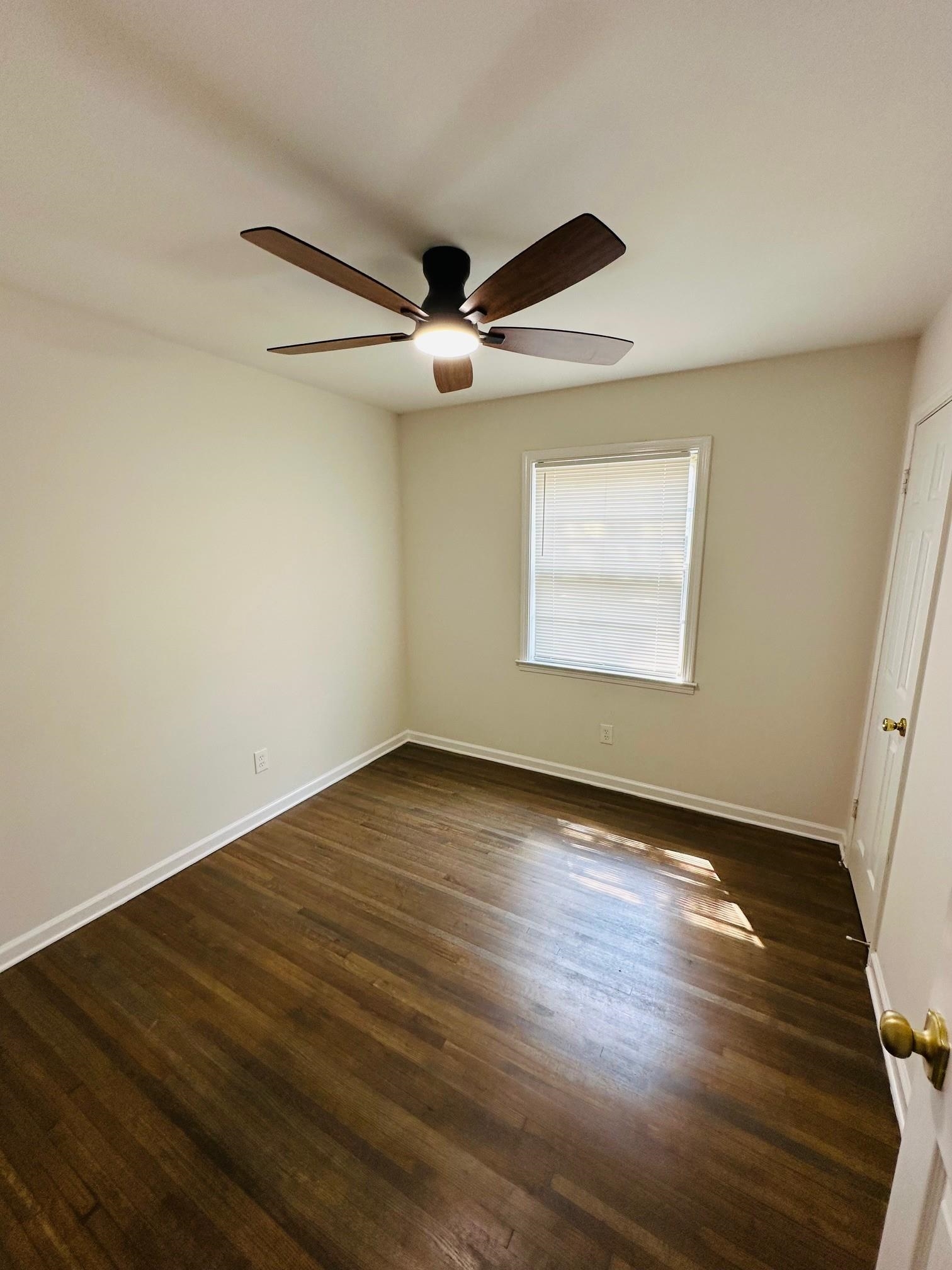 507 Tonto Road Memphis, TN 38109 - Photo 13 of 15 an empty room with wooden floor ceiling fan and windows