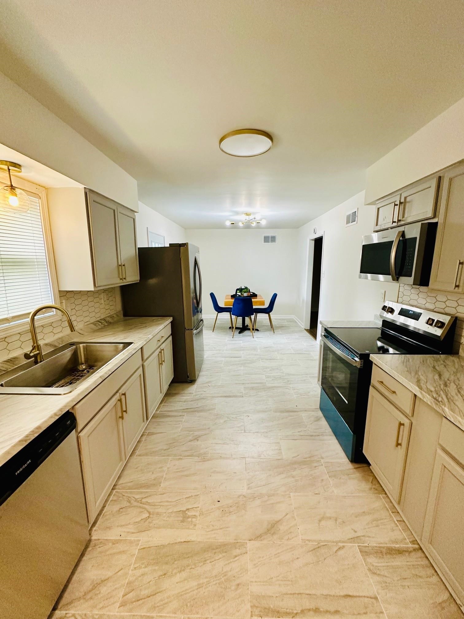 507 Tonto Road Memphis, TN 38109 - Photo 5 of 15 a large white kitchen with a stove a sink and a refrigerator