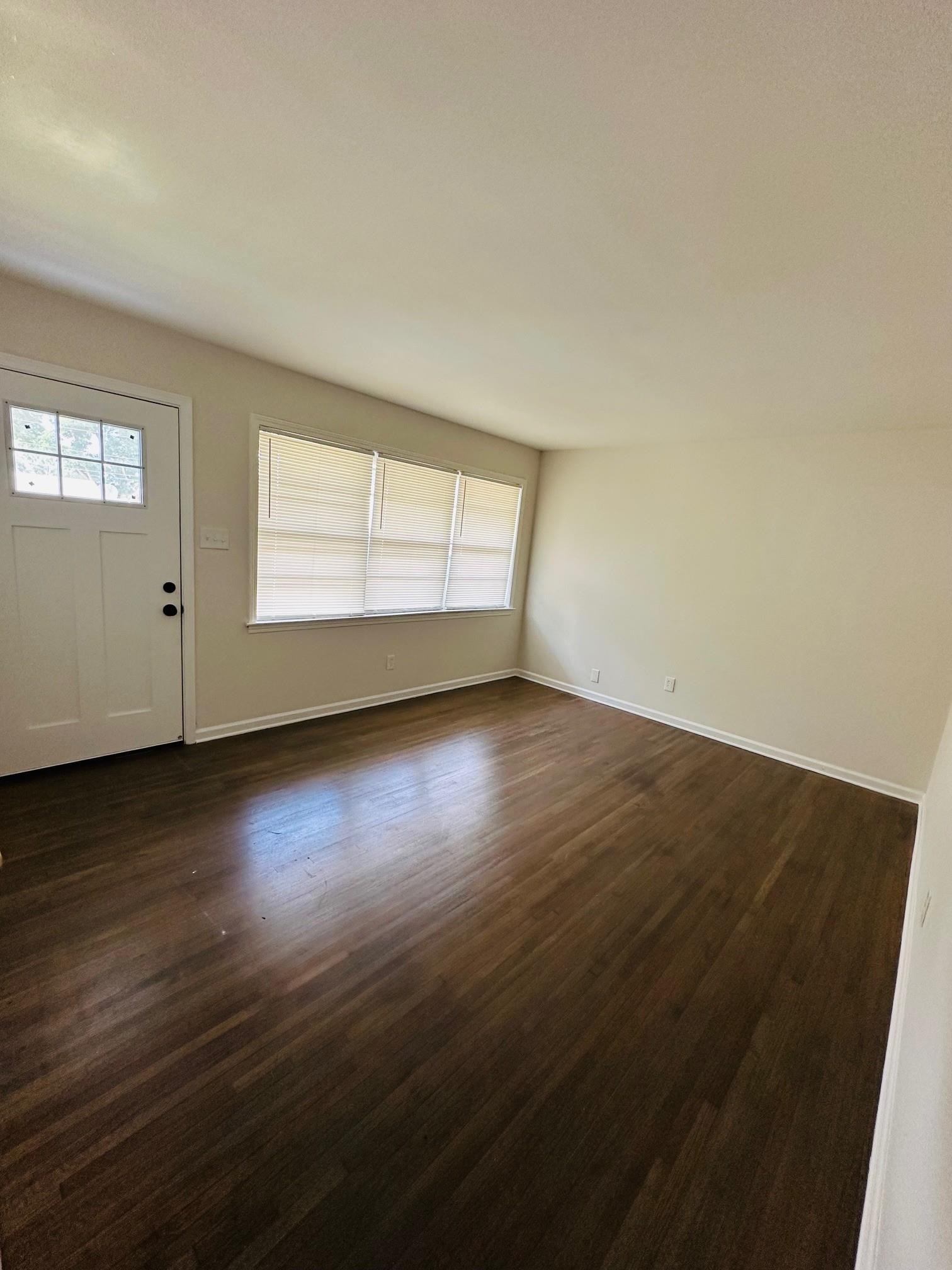 507 Tonto Road Memphis, TN 38109 - Photo 10 of 15 an empty room with wooden floor and windows