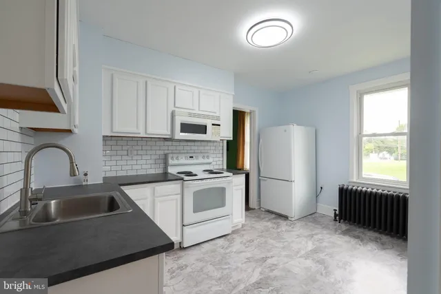 a kitchen with cabinets appliances and a sink