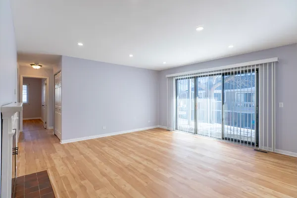 a dining room with chandelier and wooden floor