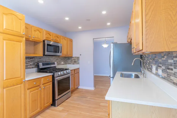a kitchen with stainless steel appliances granite countertop a stove a sink and a refrigerator