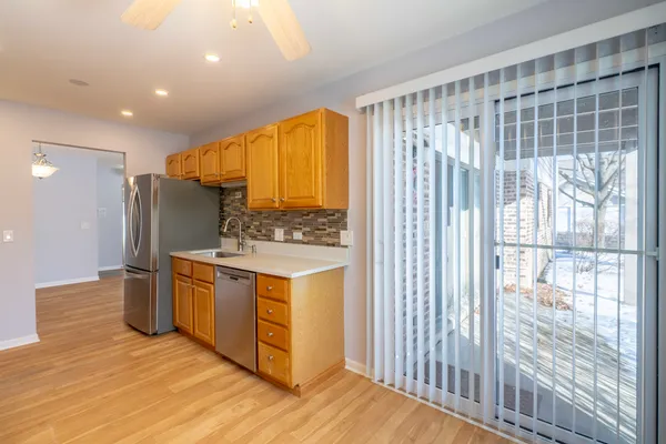 a kitchen with stainless steel appliances a stove a sink cabinets and a dining table