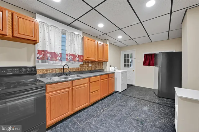 a large kitchen with stainless steel appliances granite countertop a sink window and cabinets