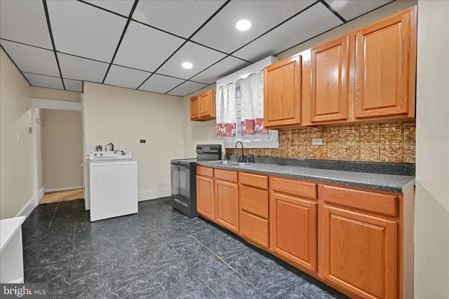 a utility room with granite countertop cabinets washer and dryer