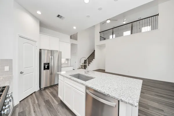 a kitchen with stainless steel appliances granite countertop a refrigerator and a sink