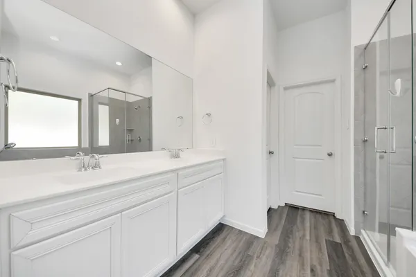 a spacious bathroom with a double vanity sink and mirror