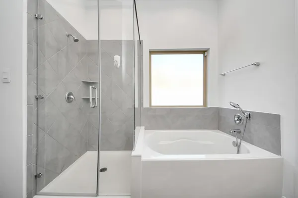 a white bath tub sitting next to a shower