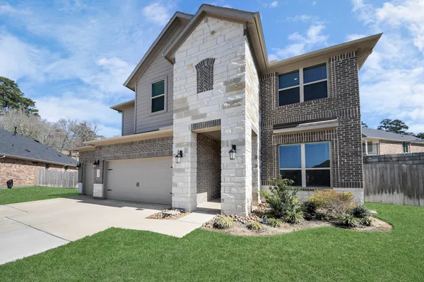 a front view of a house with a garden and yard