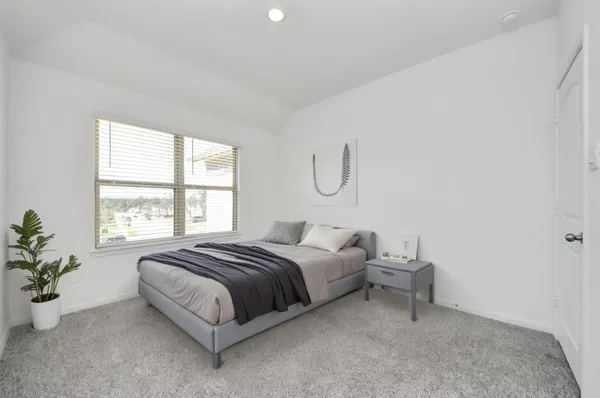 a spacious bedroom with a bed and a window