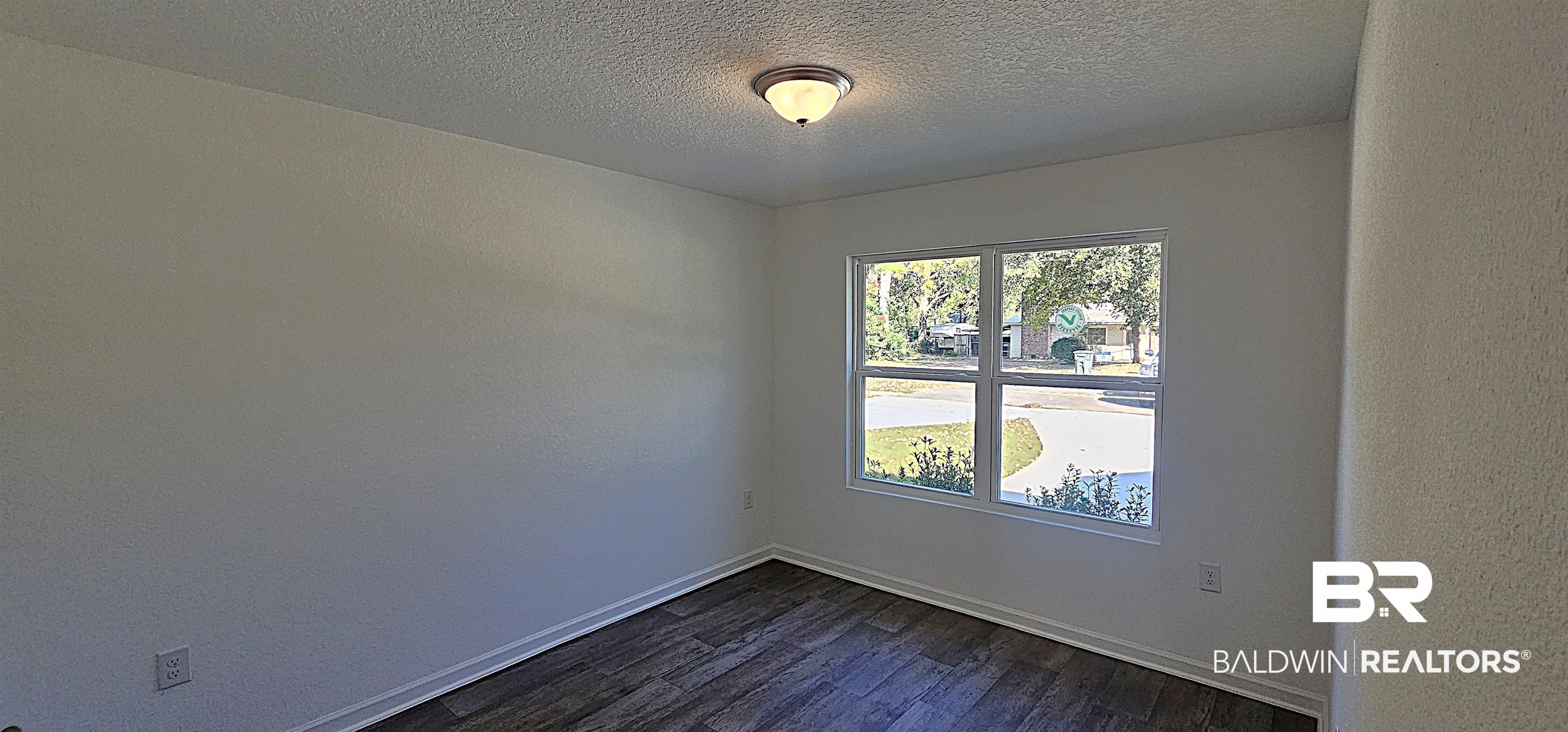 1148 Sweet Laurel Street Foley, AL 36535 - Photo 17 of 18 Spare room featuring a textured ceiling and dark hardwood / wood-style flooring